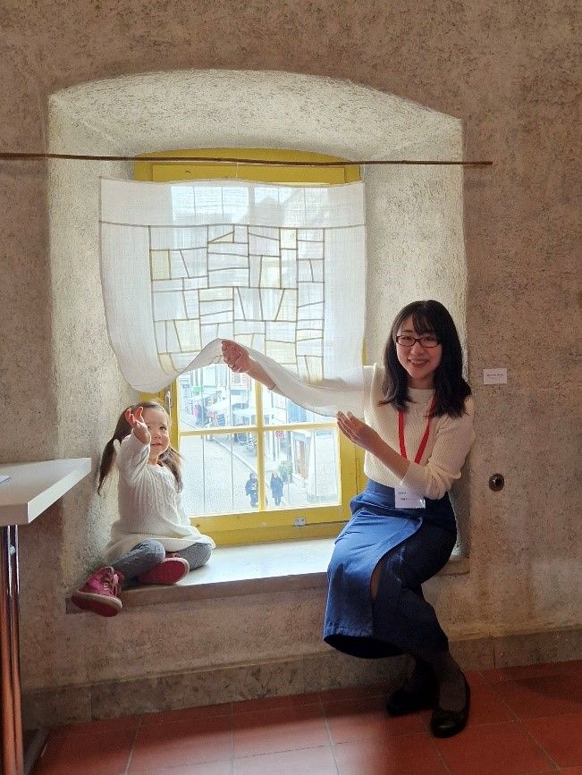 Seika Lee Klein (with her daughter) next to her bojagi artwork